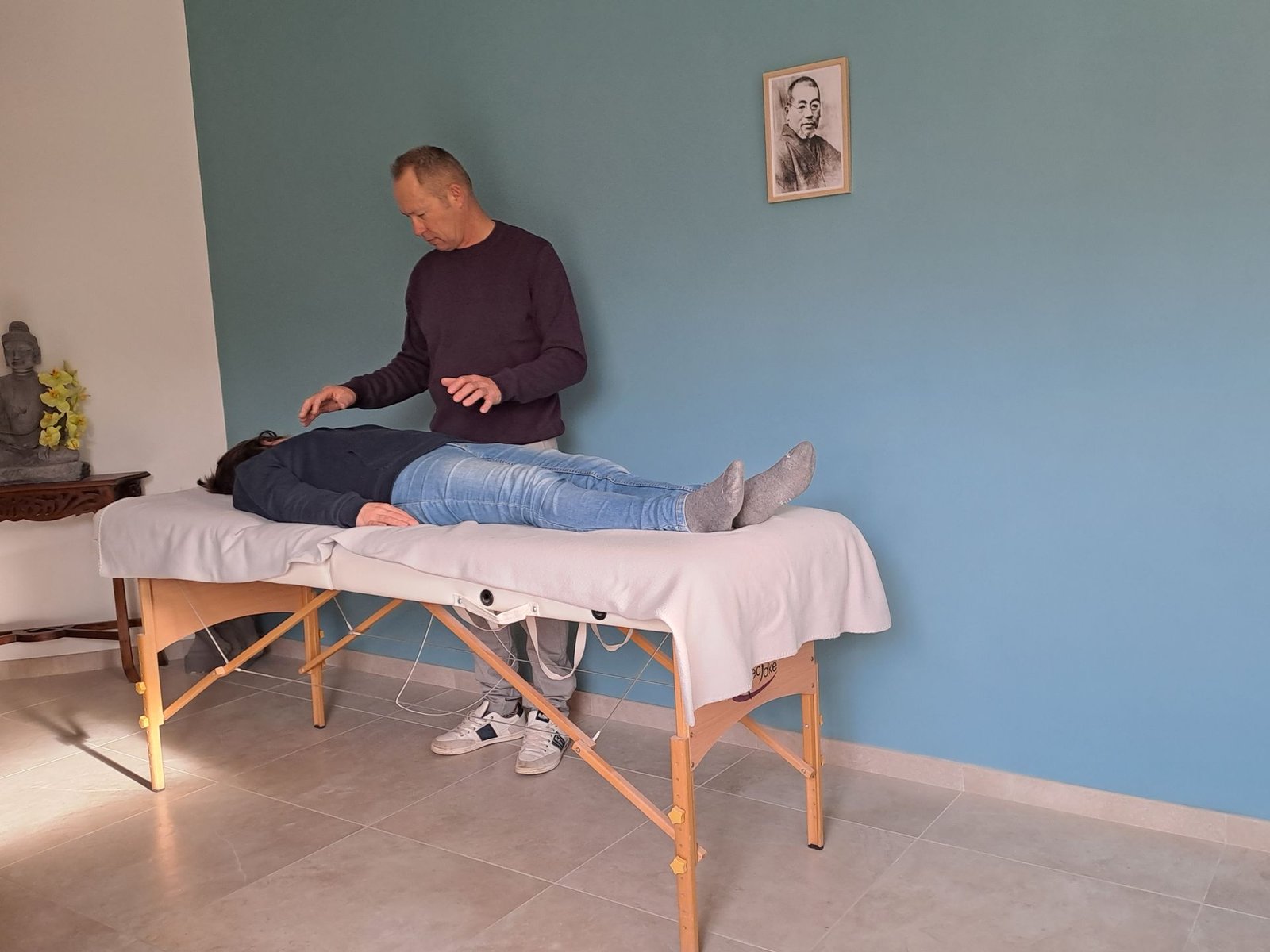 un homme donne un massage à une femme allongée sur une table de massage .
